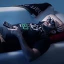 Lazt Glasses- Man wearing the lazy glasses lying on the couch watching TV